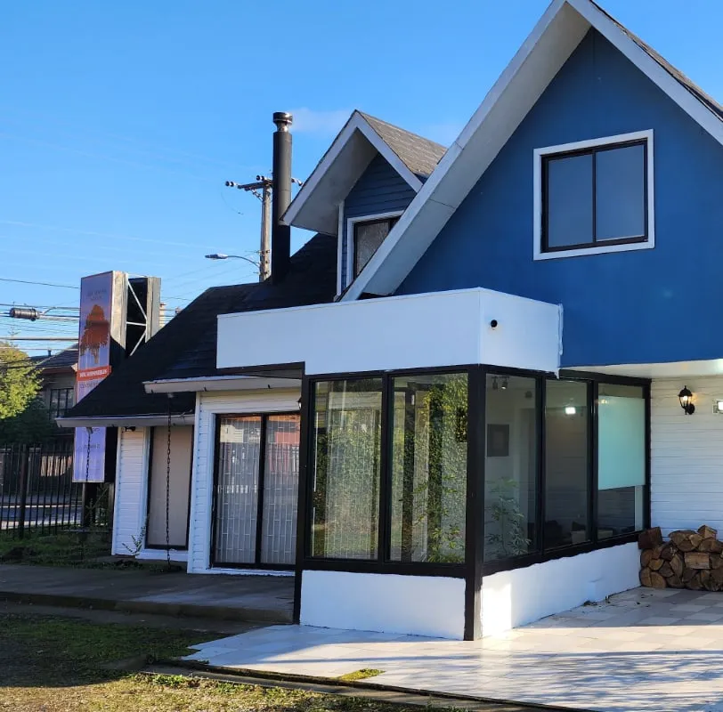 Fachada de la casa donde funciona Arrayanes Salud, con ventanales y jardín